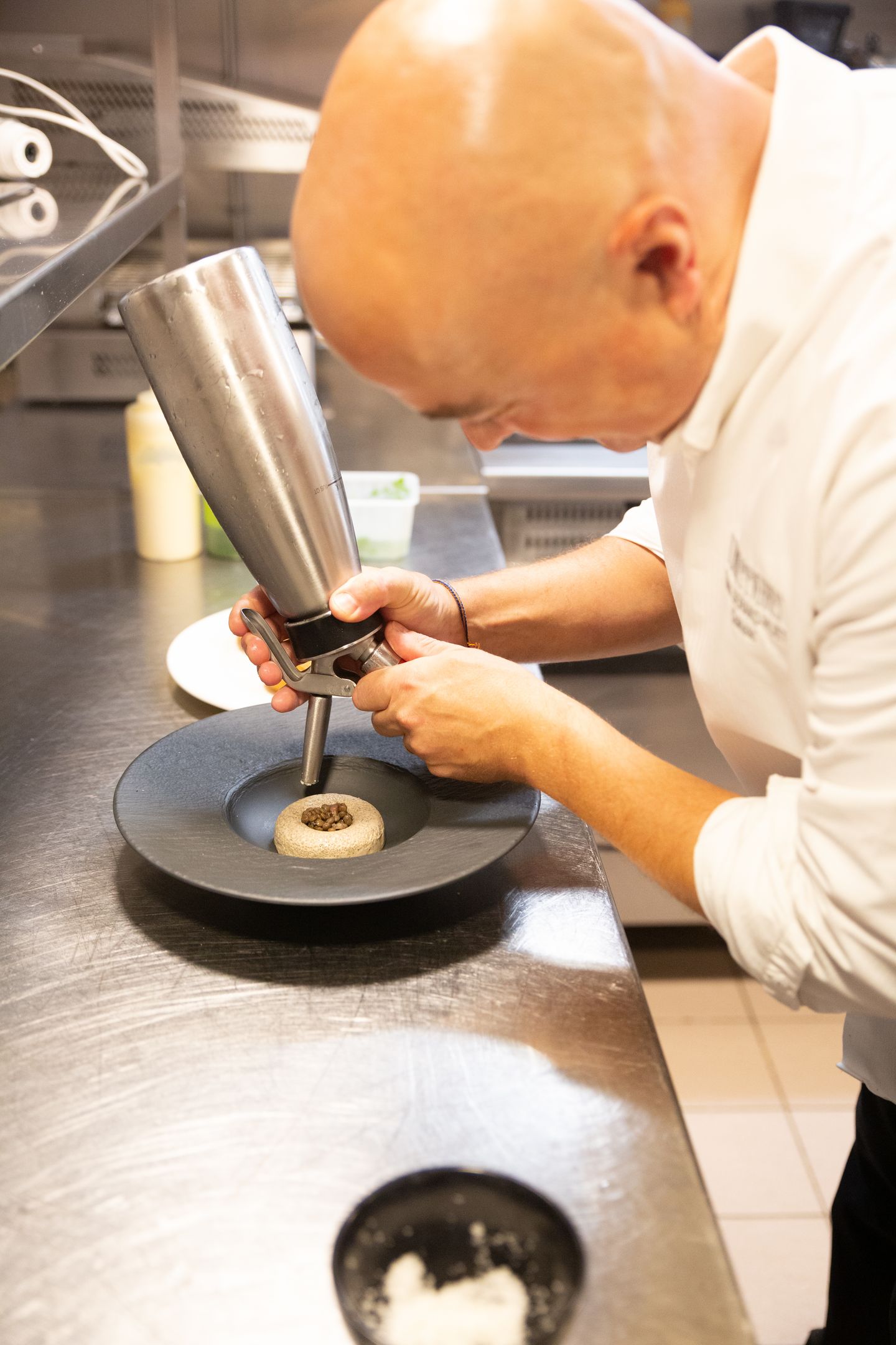 Le chef dresse une assiette en cuisine